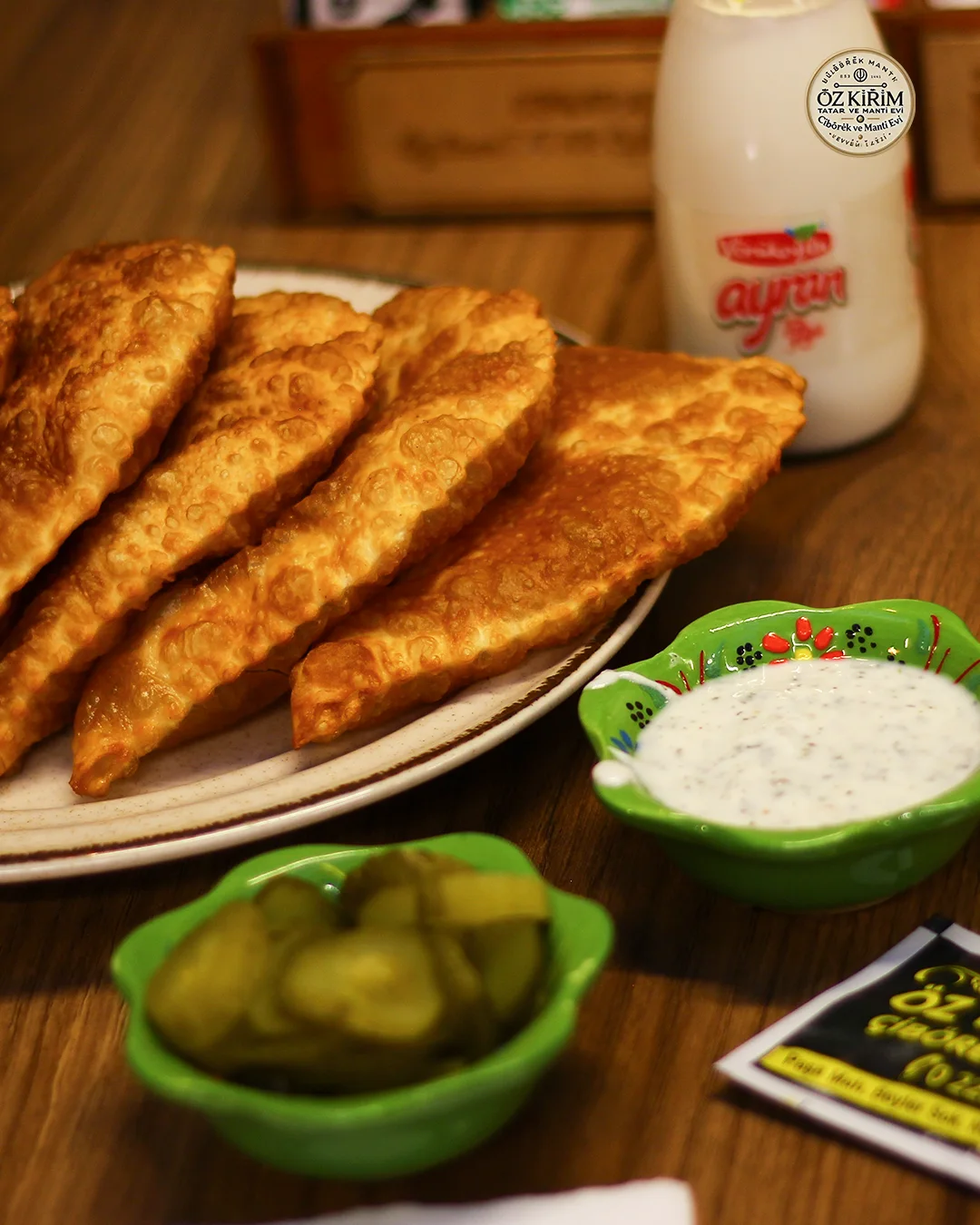 Çibörek, turşu, ayran ve soslarla hazırlanan servis tabağı